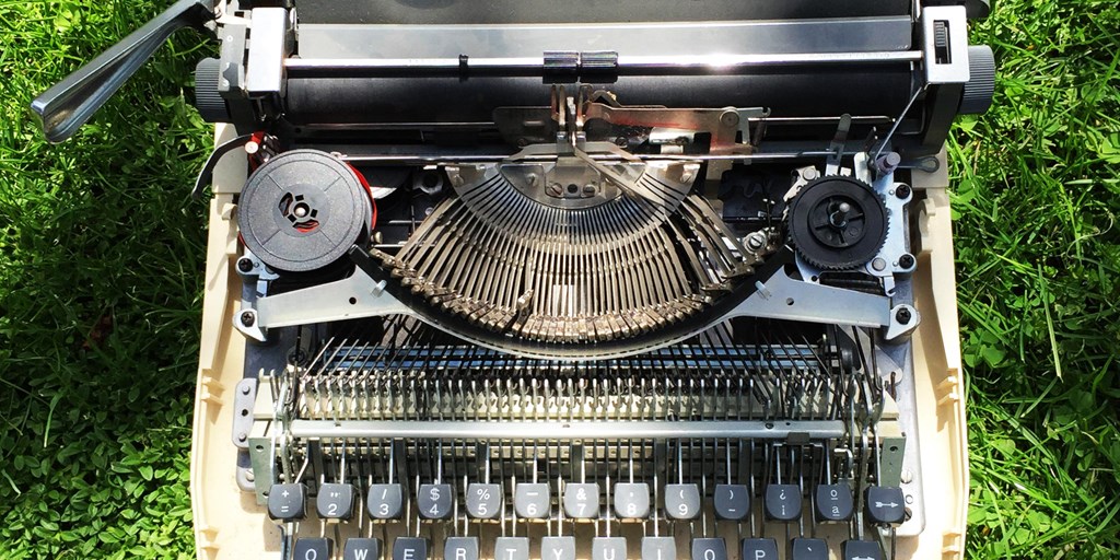 Typewriter on grass by Diego Carpentero