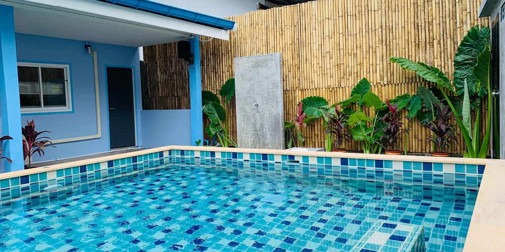 Swimming pool behind house with bamboo fence